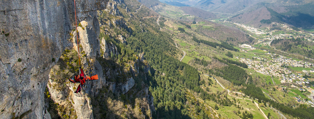 Rescate técnico en una pared de roca, con un valle de montaña al fondo. Fotografía Petzl.